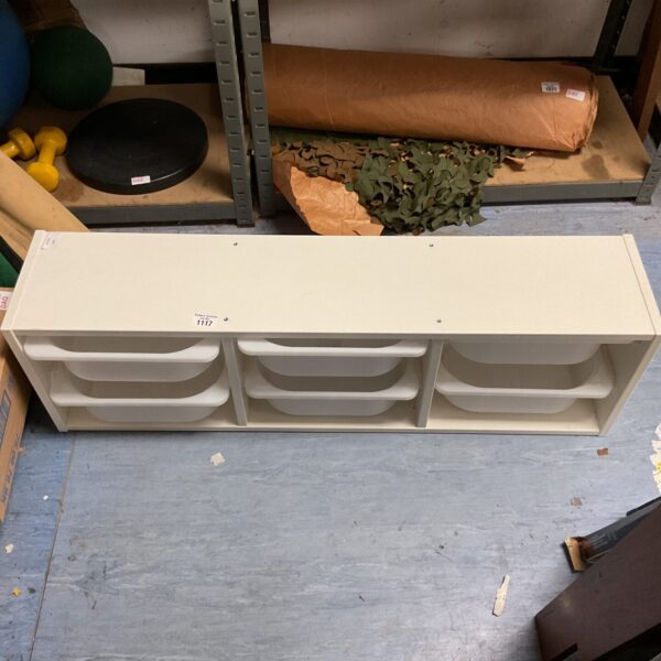 White wooden storage unit with plastic bins for organization.