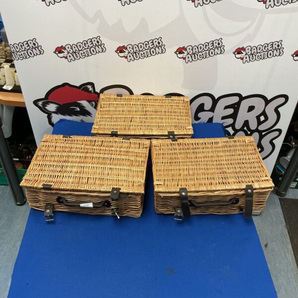 Three woven wicker baskets with handles, ideal for hampers.