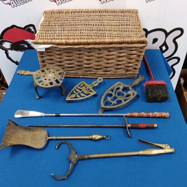 Vintage wicker hamper with brass fireplace tools and trivets.