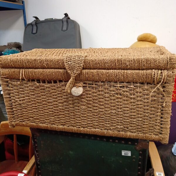 Vintage wicker ottoman chest for storage and seating.
