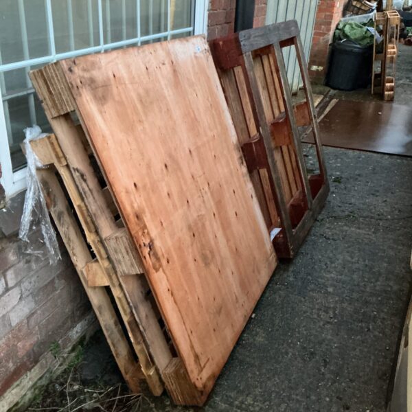 Lot of five weathered wooden pallets for DIY projects.
