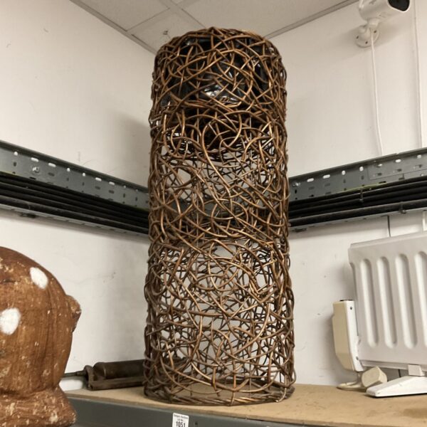 Tall woven twig pedestal for garden or home display.