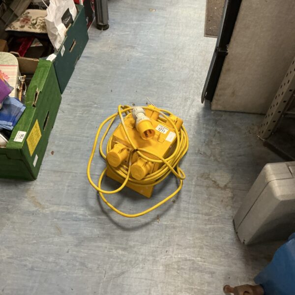 Yellow 110v connector box with coiled cable for site power.