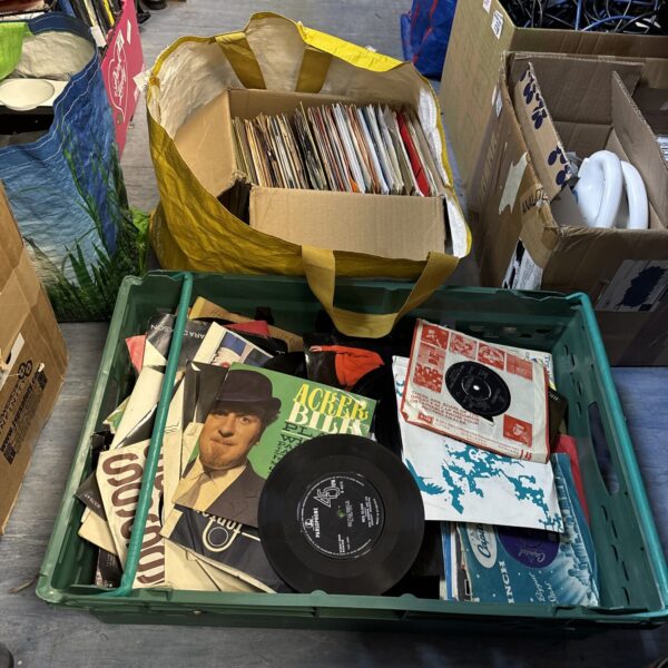 Mixed lot of 7 inch vinyl records in a crate.