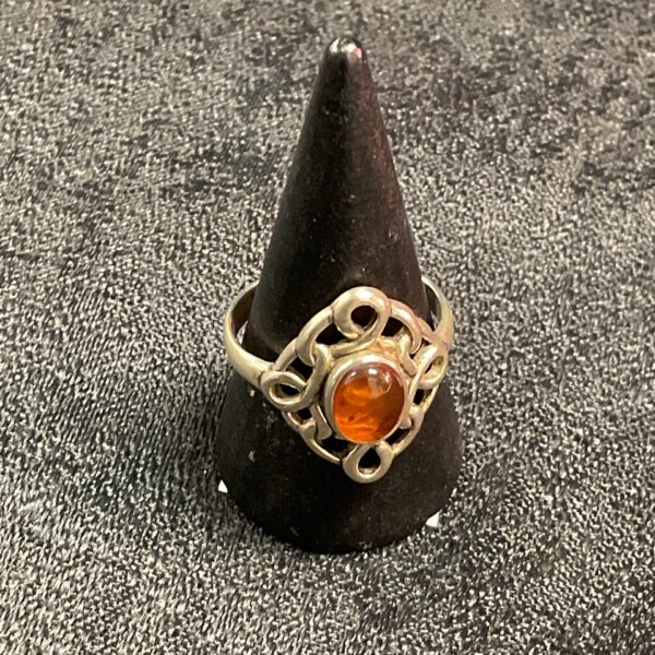 Close-up of a 925 silver ring with a warm amber stone.