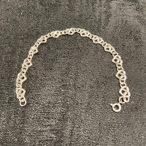 Close-up of a 925 silver heart link bracelet.