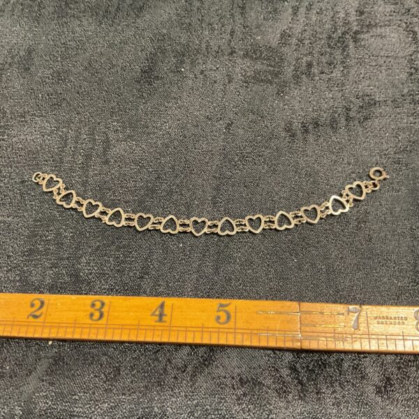 Close-up of a 925 silver heart link bracelet.