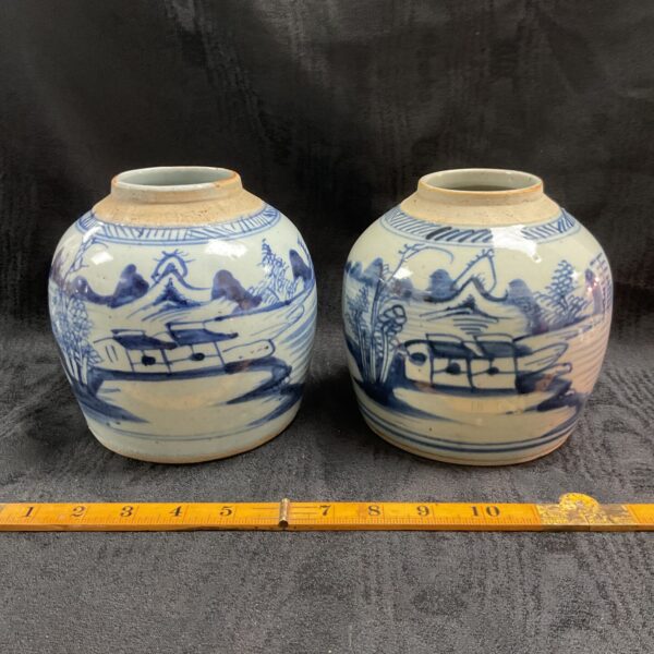 Pair of antique Chinese ginger jars with blue and white landscape design.