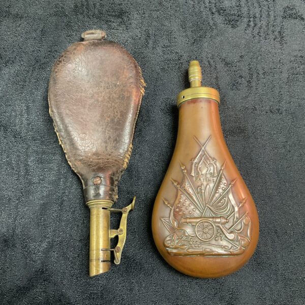Antique Colt powder flask with leather covering and embossed design.