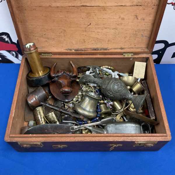 Antique wooden chest filled with brass, jewellery and a buffalo bust.