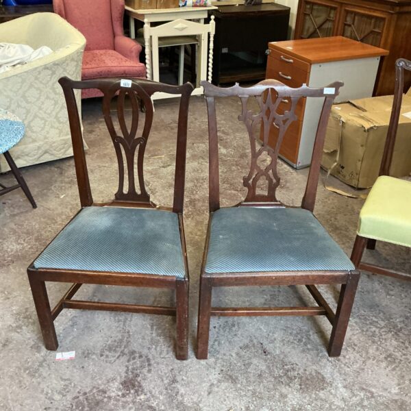 Pair of antique dark wood hall chairs with curved backs.