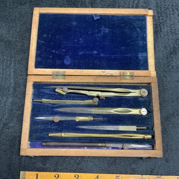 Antique M40 drawing instrument set displayed open in its wooden box.