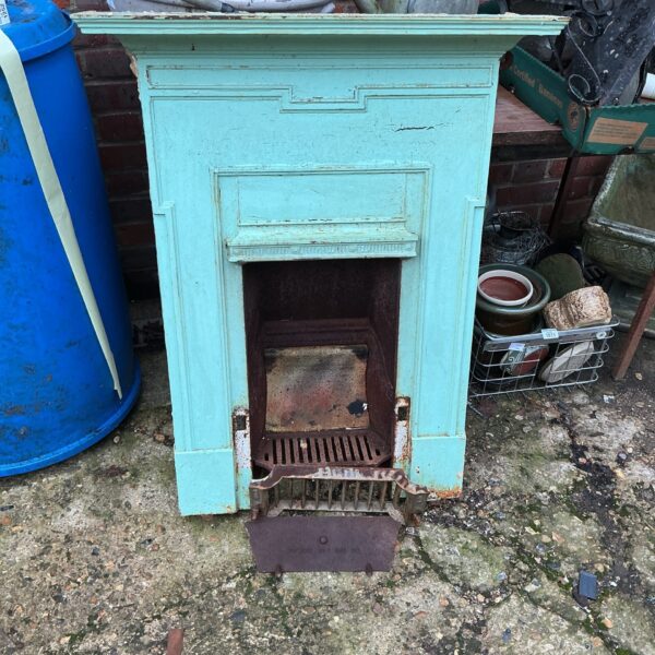 Antique metal fire surround with decorative front panel.
