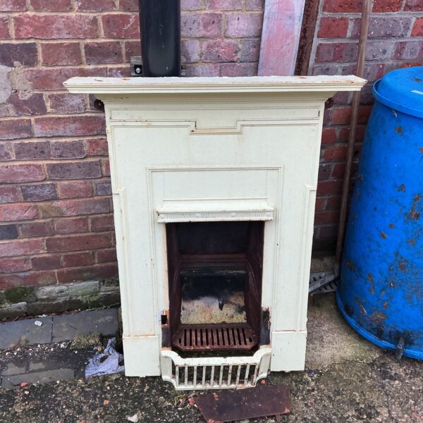 Decorative antique metal fireplace with aged patina.