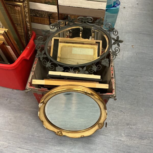 Antique oval gilt framed mirror with ornate detailing.