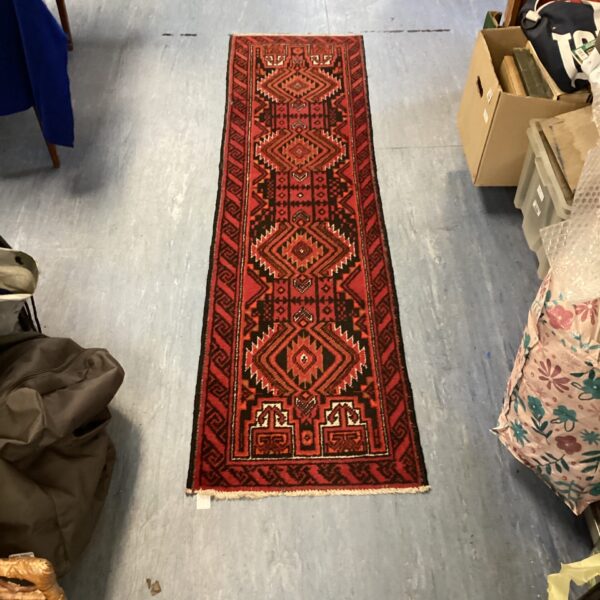 Antique Persian rug runner with traditional patterns and rich colours.