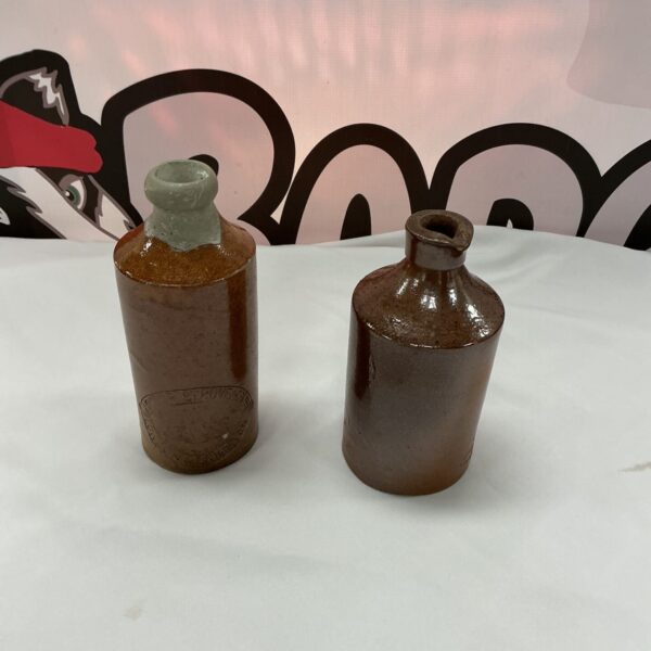 Pair of antique pottery bottles with warm earthy tones.