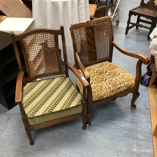 Antique oak armchair with a woven reed back and upholstered seat.