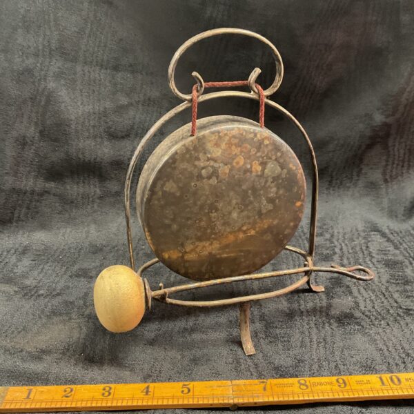 Antique silver plate dinner gong on a dark surface.