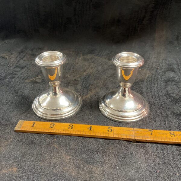 Antique pair of sterling silver weighted candlesticks on a ruler.