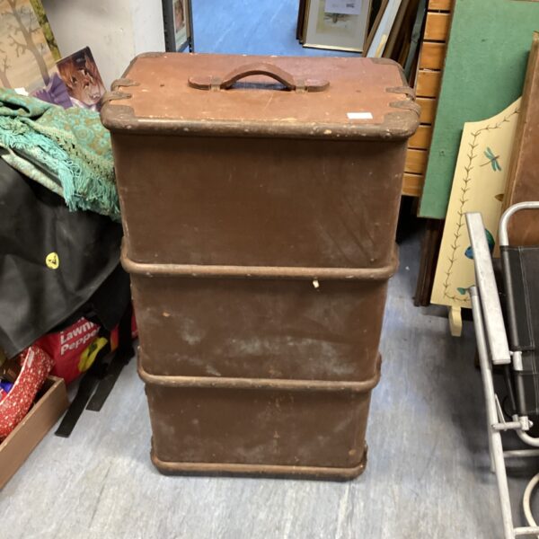 Side view of an antique travel trunk with aged exterior.