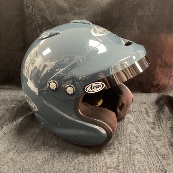 Blue Arai race helmet with clear visor, side view.