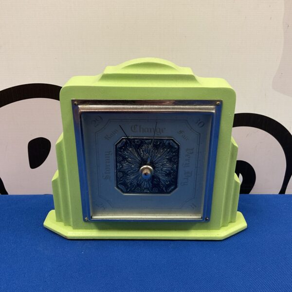 Vintage green Art Deco Smiths barometer for weather forecasting.