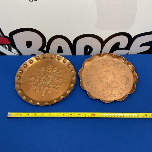 Antique Art Nouveau copper trays with embossed floral designs.