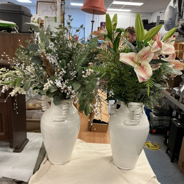 White vase with vibrant artificial flower arrangement for home decor.