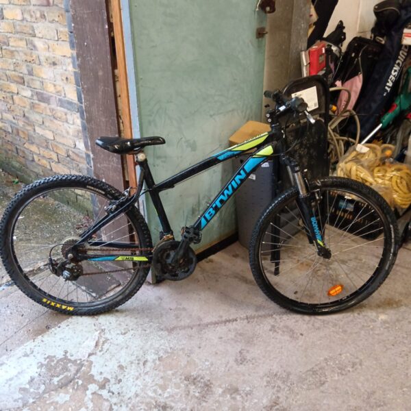 Used B twin rockrider mountain bike in outdoor setting.