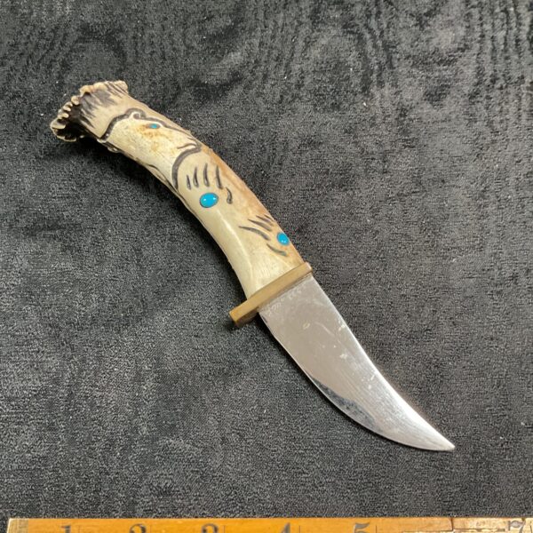 Vintage bear handle hunting knife with signed blade and leather sheath.