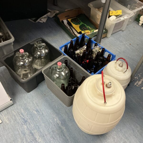 Lot of vintage beer bottles and glass demijohns for brewing.