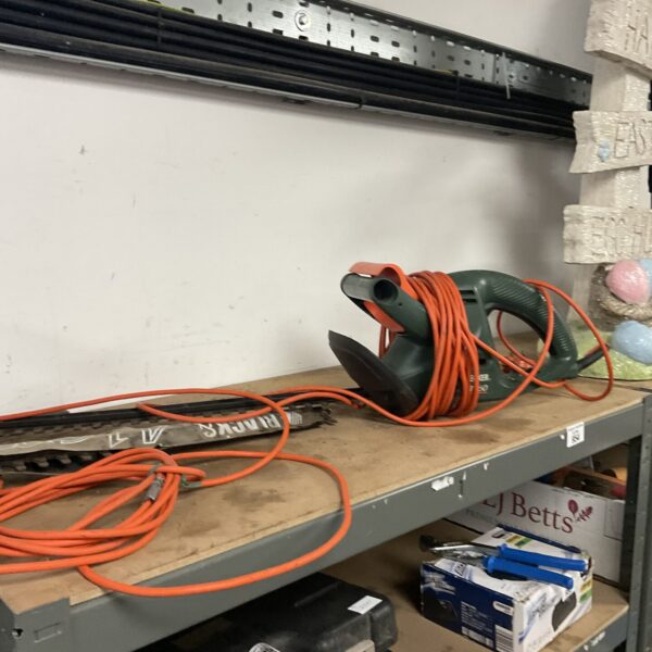 Black & Decker electric hedge trimmer with cable repair, ideal for garden maintenance.