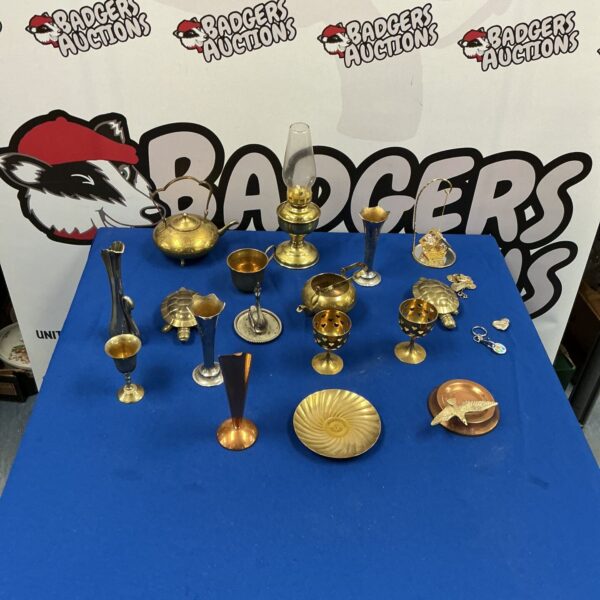 Vintage brass and copper ornaments including an oil lamp on display.