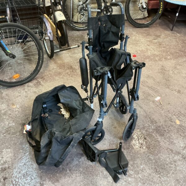 Care Co folding wheelchair with attached bag, a portable mobility aid.