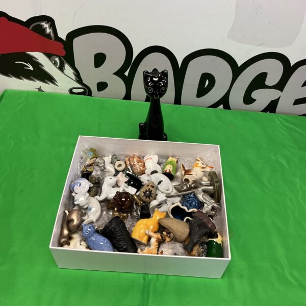 Collection of porcelain cat ornaments on display.