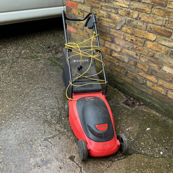 Used Champion electric lawn mower for garden maintenance.