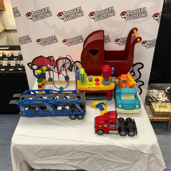 Assorted childrens toys including a puzzle, moover, and trucks.