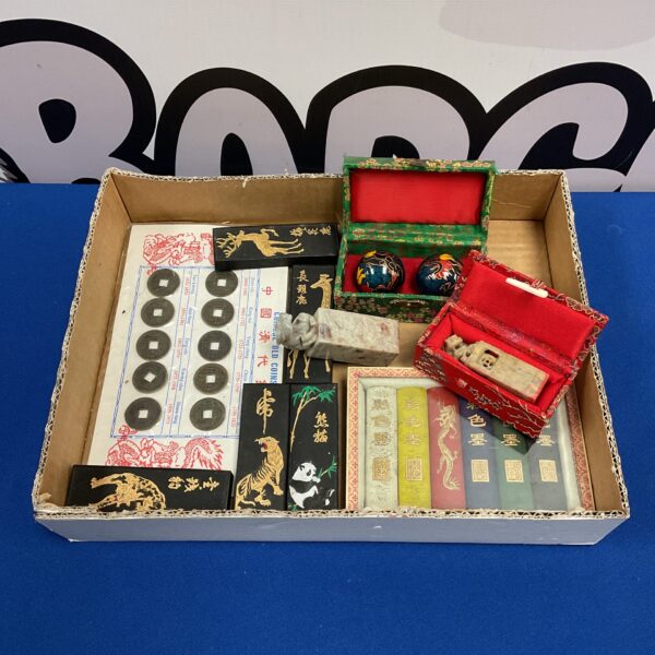 Tray of vintage Chinese coins, marble seals, and stress balls.