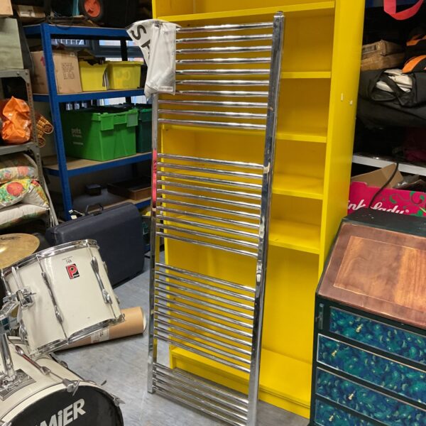 Large chrome heated towel rail in a bathroom setting.