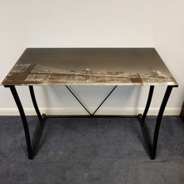 Modern glass top desk with cityscape design for home office.