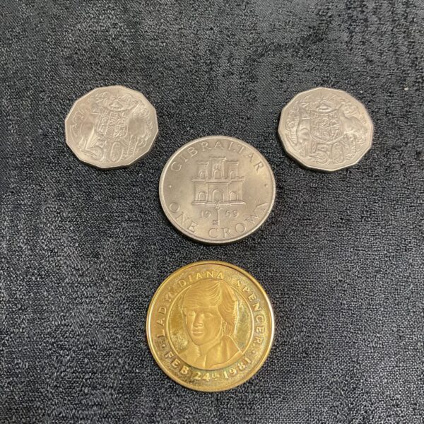 Close-up of commemorative coins including Australian and Gibraltar coins.