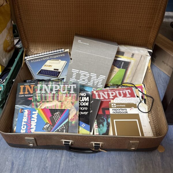 Vintage computing manuals and books in a suitcase.