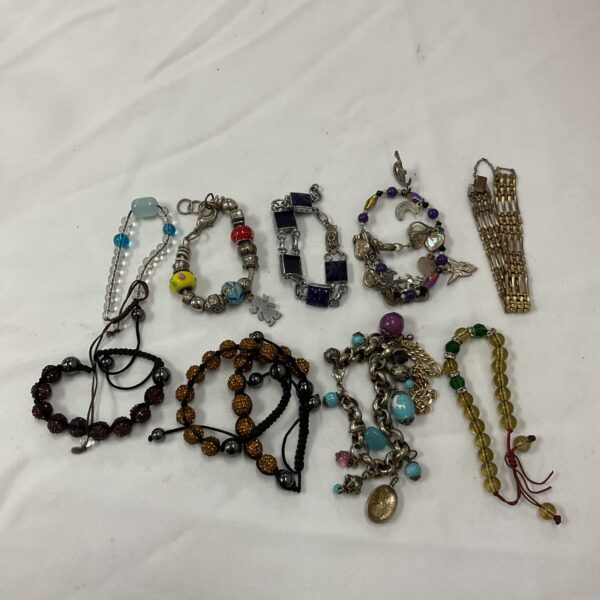 Mixed lot of ten costume jewellery bracelets on display.