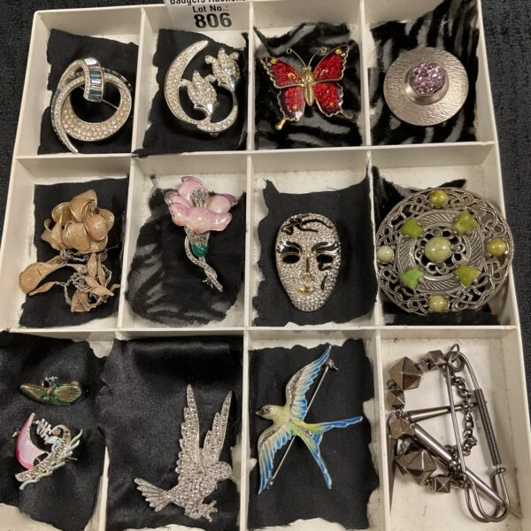 Vintage costume jewellery brooches displayed as a lot, offering a variety of designs.