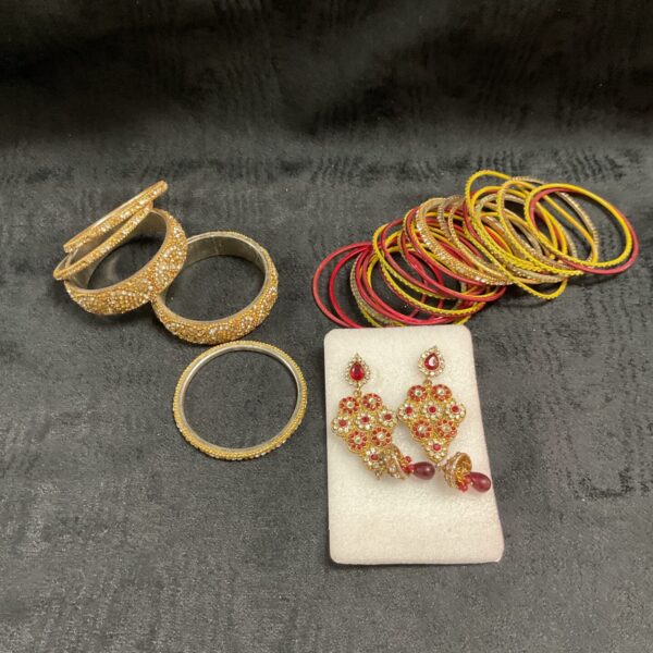 Vintage costume jewelry lot featuring gold bracelets and ornate earrings.
