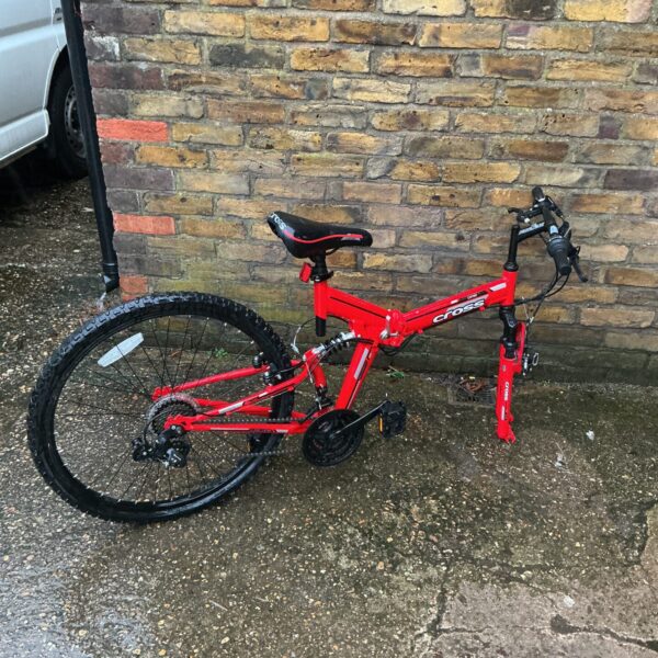 Red Cross mountain bike needing repair, missing front wheel.