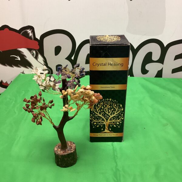 Polished gemstone crystal healing tree with geode base.