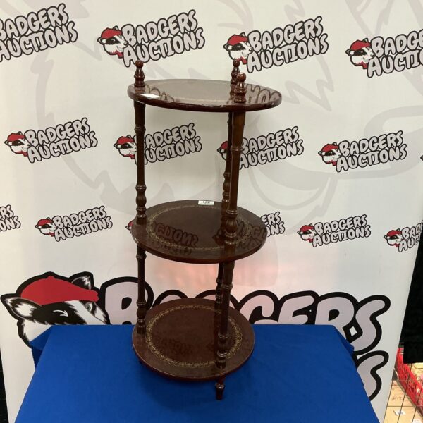 Dark wood three-tier plant stand for displaying plants.