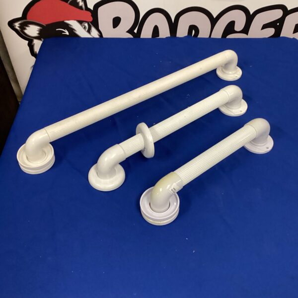 Lot of three white disabled bathroom handles for accessibility.